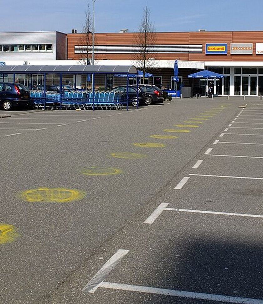 Parkeerterrein met witte belijning voor een winkelstrip